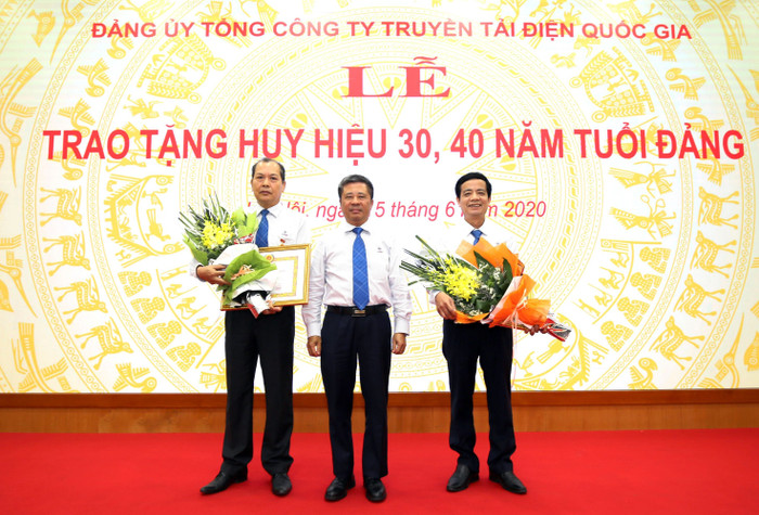 Đồng chí Đặng Phan Tường - Bí thư Đảng ủy, Chủ tịch Hội đồng thành viên EVNNPT trao Huy hiệu và tặng hoa chúc mừng hai Đảng viên nhận danh hiệu 30 năm và 40 năm tuổi Đảng.