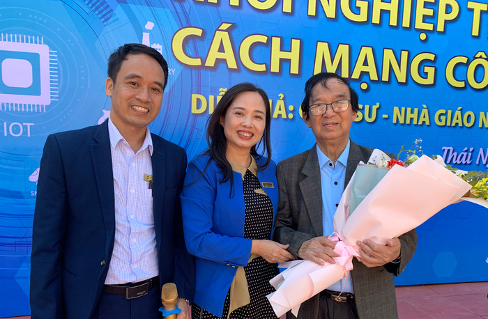 Nhà giáo Ngô Thị Quyên - Hiệu trường nhà trường và thầy Nguyễn Văn Duẩn - Phó hiệu trưởng Trường Trung học phổ thông Gang Thép tặng hoa cho Giáo sư Nguyễn Lân Dũng. Ảnh: Tùng Dương.