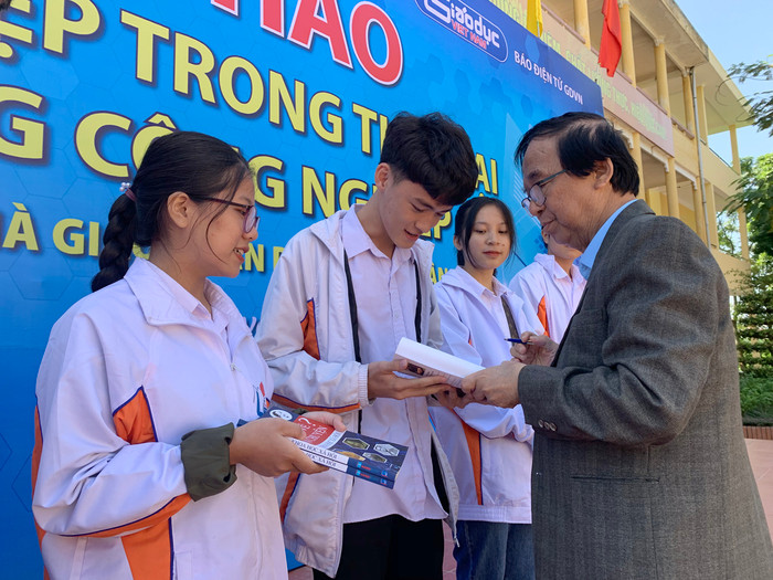 Nhà giáo nhân dân - Giáo sư Nguyễn Lân Dũng đang tặng sách cho đại diện các em học sinh Trường Trung học phổ thông Gang Thép. Ảnh: Tùng Dương.