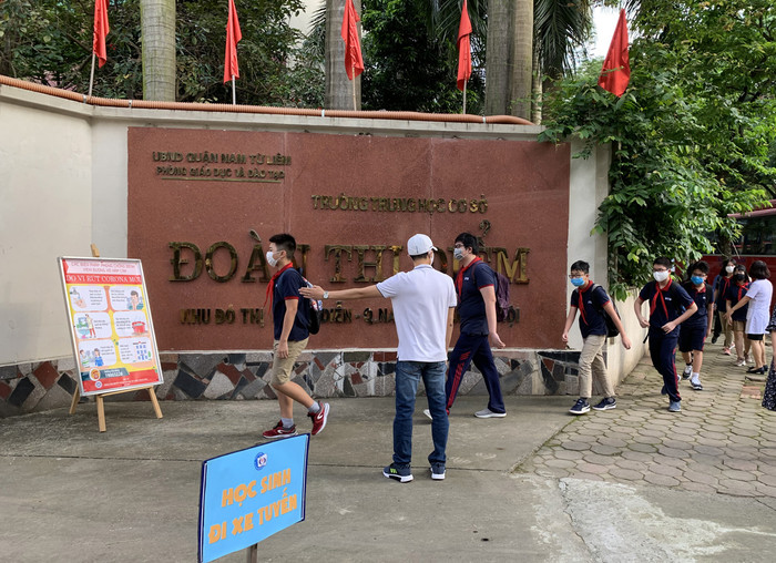 Học sinh đi thành hàng, giãn cách khi đi vào trường. Ảnh: Tùng Dương. Học sinh đi thành hàng, giãn cách khi đi vào trường. Ảnh: Tùng Dương.