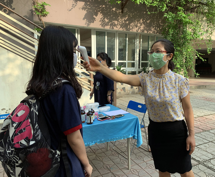 Trường Trung học cơ sở Đoàn Thị Điểm phân luồng khoảng cách, đo thân nhiệt từ cổng trước khi học sinh vào trường. Ảnh: Tùng Dương. Trường Trung học cơ sở Đoàn Thị Điểm phân luồng khoảng cách, đo thân nhiệt từ cổng trước khi học sinh vào trường. Ảnh: Tùng Dương.