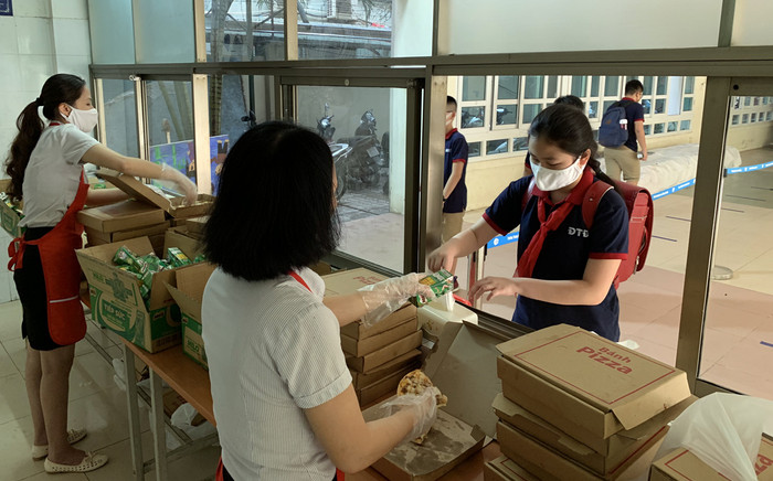 Học sinh nhận khẩu phần ăn sáng sẽ tản ra ăn ngoài sân trường, tuân thủ giãn cách không tụ tập trong phong ăn. Ảnh: Tùng Dương. Học sinh nhận khẩu phần ăn sáng sẽ tản ra ăn ngoài sân trường, tuân thủ giãn cách không tụ tập trong phong ăn. Ảnh: Tùng Dương.