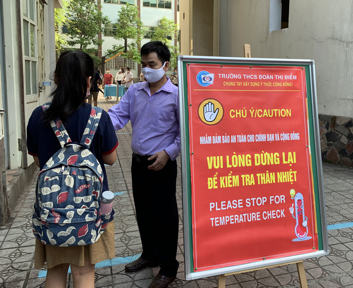 Trường luôn bố trí cán bộ tại các cổng trường để nhắc nhở học sinh về các biện pháp phòng dịch. Ảnh: Tùng Dương. Trường luôn bố trí cán bộ tại các cổng trường để nhắc nhở học sinh về các biện pháp phòng dịch. Ảnh: Tùng Dương.