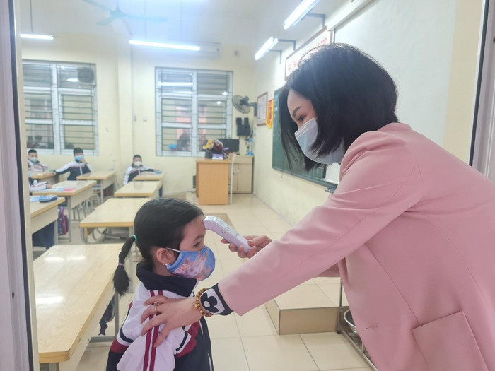 Học sinh Trường Tiểu học Chu Văn An được đo thân nhiệt trước khi vào lớp (Ảnh: Lã Tiến)