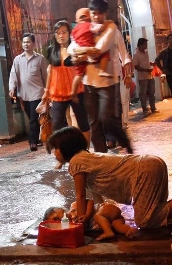 Nhiều người qua đường cũng chỉ lướt qua những cảnh đời bất hạnh. Ảnh. Tuổi Trẻ.