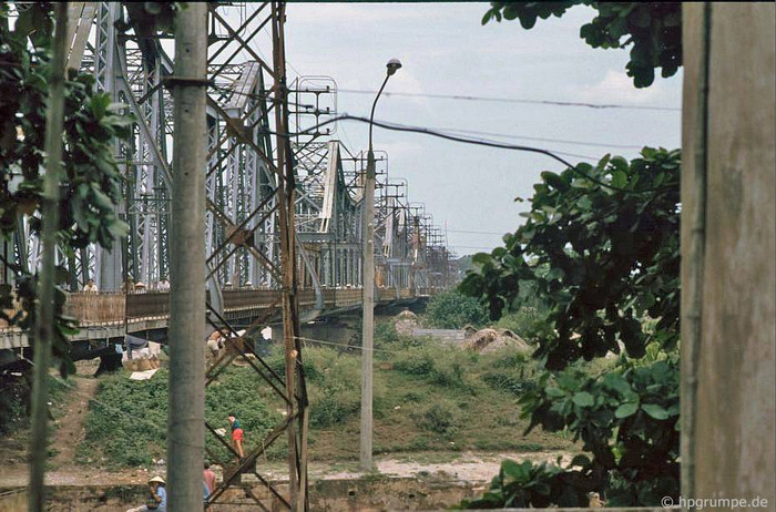 Cầu Long Biên là cây cầu thép đầu tiên bắc qua sông Hồng tại Hà Nội, do Pháp xây dựng (1899-1902), đặt tên là cầu Doumer, theo tên của Toàn quyền Đông Dương Paul Doumer. Dân gian còn gọi là cầu sông Cái hay cầu Bồ Đề (vì nó được bắt qua bến Bồ Đề thuộc huyện Gia Lâm). Ảnh chụp năm 1991. Cầu Long Biên là cây cầu thép đầu tiên bắc qua sông Hồng tại Hà Nội, do Pháp xây dựng (1899-1902), đặt tên là cầu Doumer, theo tên của Toàn quyền Đông Dương Paul Doumer. Dân gian còn gọi là cầu sông Cái hay cầu Bồ Đề (vì nó được bắt qua bến Bồ Đề thuộc huyện Gia Lâm). Ảnh chụp năm 1991.