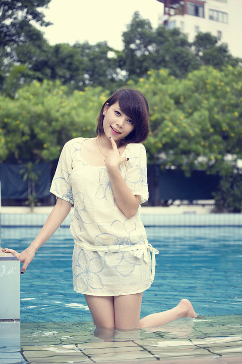 Đổi style với tóc ngắn tinh nghịch, váy hoa nền nã, Linh Rin như một bông hoa xuân dưới làn nước mát.