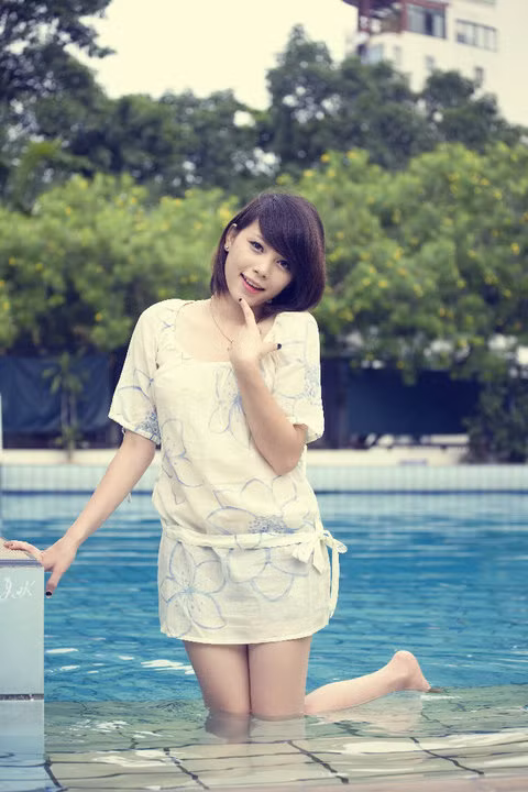 Đổi style với tóc ngắn tinh nghịch, váy hoa nền nã, Linh Rin như một bông hoa xuân dưới làn nước mát.