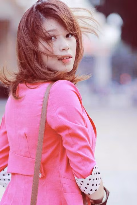 Chiếc áo hồng ngọt ngào cô gái diện tưởng đã nổi bật lắm, đẹp lắm, nhưng hóa ra chưa đủ sức níu chân chàng gió. Làn tóc xõa buông lơi mềm mại.