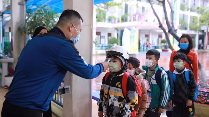 Học sinh Trường Tiểu học Yên Thanh (thành phố Uông Bí) được đo thân nhiệt trước khi vào lớp (Ảnh: CTV)