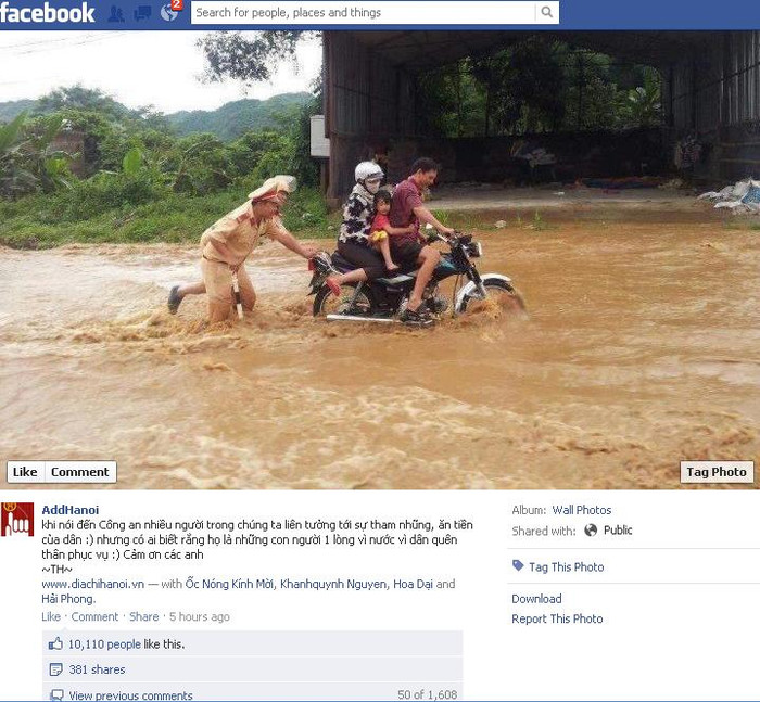 Ảnh hai chiến sĩ cảnh sát giao thông đẩy xe giúp người dân trong lũ