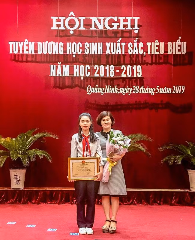 Đào Khánh Huyền và cô Nguyễn Thị Mai Dung, giáo viên bộ môn Ngữ văn của em tại Lễ tuyên dương học sinh xuất sắc, tiêu biểu năm học 2018-2019 do Sở Giáo dục và Đào tạo Quảng Ninh tổ chức. (Ảnh: Đỗ Quang)