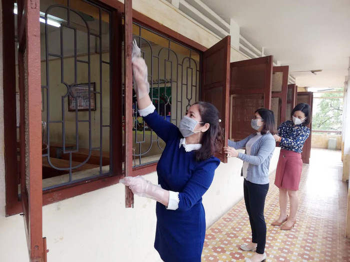 Giáo viên Trường Trung học phổ thông Hàng Hải lau chùi phòng học để chuẩn bị đón học sinh quay lại trường (Ảnh: LT)