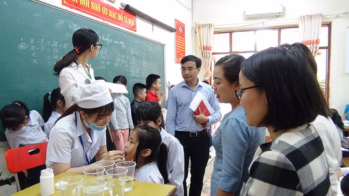 Cán bộ Y tế cho trẻ uống thuốc tẩy giun tại Trường Tiểu học Hạ Long (thành phố Hạ Long, Quảng Ninh) - (Ảnh: Minh Khương)
