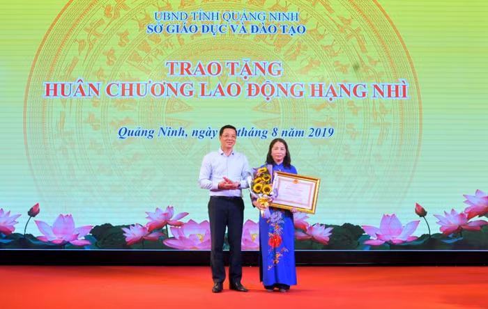 Thừa ủy quyền của Chủ tịch nước, lãnh đạo tỉnh Quảng Ninh trao Huân chương Lao động hạng Nhì cho bà Vũ Liên Oanh, Giám đốc Sở Giáo dục và Đào tạo. (Ảnh: CTV)