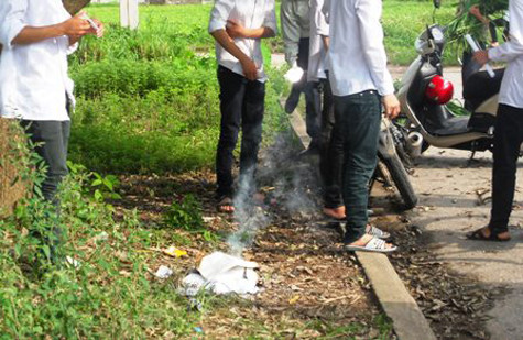 Thí sinh lật tài liệu kiểm tra trước khi ném vào đống lửa Thí sinh lật tài liệu kiểm tra trước khi ném vào đống lửa