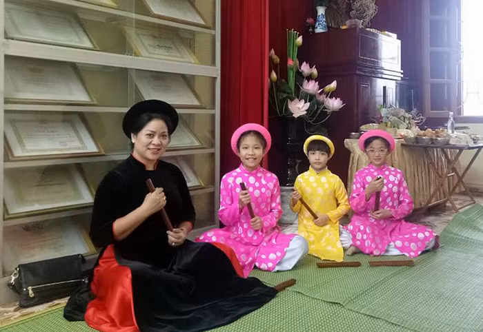 Hiệu trưởng Trường Tiểu học Nguyễn Công Trứ biểu diễn môn nghệ thuật ca trù cùng học sinh nhà trường (Ảnh: CTV)