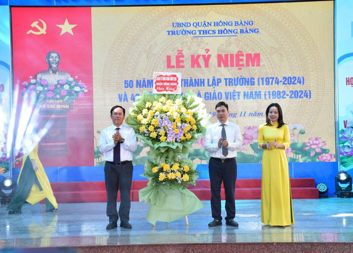 Ông Lê Ngọc Trữ - Bí thư Quận ủy Hồng Bàng thay mặt lãnh đạo quận tặng hoa chúc mừng nhà trường (Ảnh: LT) GDVN_thcs-hong-bang-don-co-1.jpg