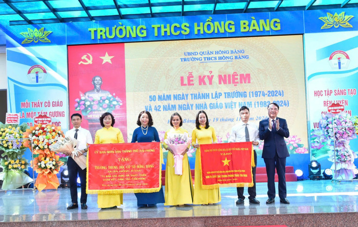 Ông Lê Khắc Nam - Phó chủ tịch Uỷ ban nhân dân thành phố trao Cờ thi đua của Chính phủ và Bức trướng của Uỷ ban nhân dân thành phố tặng Trường Trung học cơ sở Hồng Bàng (Ảnh: LT) GDVN_thcs-hong-bang-don-co-3.jpg