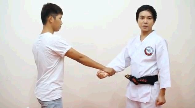 Hình ảnh thầy Hiếu (phải) hướng dẫn các tư thế võ giúp các bạn trẻ thoát hiểm trong những tình huống xấu. Ảnh chụp màn hình.