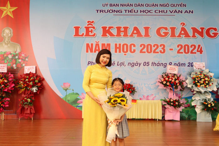 Cô giáo Phạm Thị Diện - Hiệu trưởng Trường Tiểu học Chu Văn An tặng hoa em Nguyễn Minh Anh (lớp 1A3) đạt Huy chương Vàng cờ vua cấp Quốc gia (Ảnh: LT)