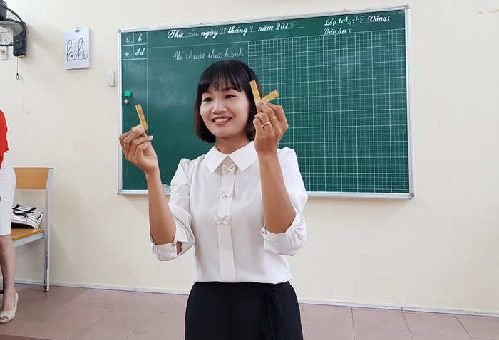 Cô giáo Hoàng Thị Hoa hướng dẫn học sinh lớp 1 tạo hình chú mèo từ lá cây khô (Ảnh: Lã Tiến)