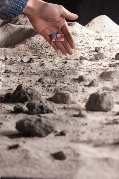 Cờ được làm từ giấy vò nát và dây điện. Trái Đất là một đoạn video được chiếu trên tường, lấy cảm hứng từ sứ mệnh Apollo 11.