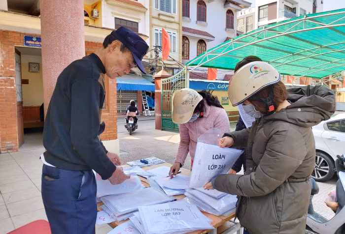 Các phụ huynh tới lấy bài tập cho con tại trường (Ảnh: Lã Tiến)