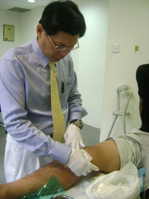 Bác sĩ Tan Jee Lim đang kiểm tra chấn thương của Quang Thanh. Bác sĩ Tan Jee Lim đang kiểm tra chấn thương của Quang Thanh.