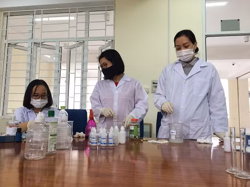 Các thầy, cô giáo của bộ môn Hóa - Sinh - Thể dục pha chế nước sát khuẩn tay theo công thức của WHO (Ảnh: Nhà trường cung cấp)