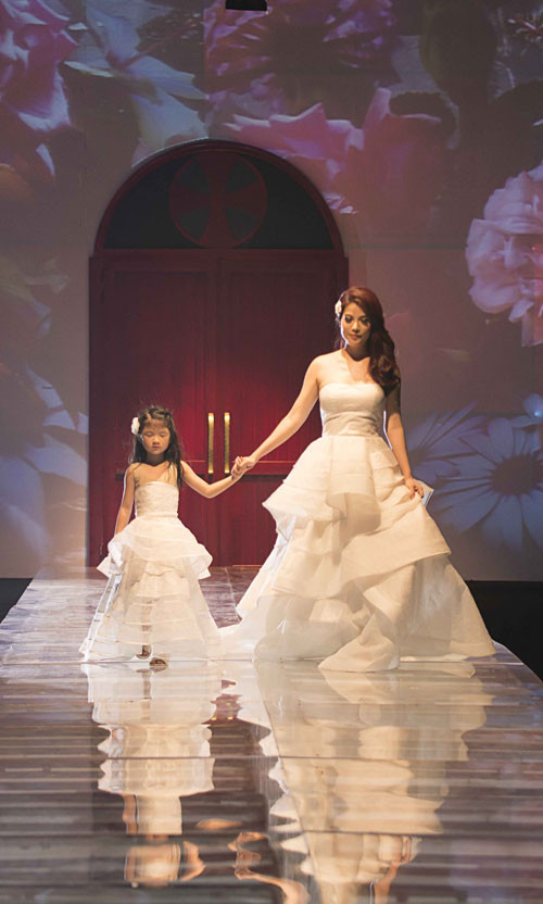 Cô bé tự tin cầm tay mẹ đi trên sàn catwalk Cô bé tự tin cầm tay mẹ đi trên sàn catwalk