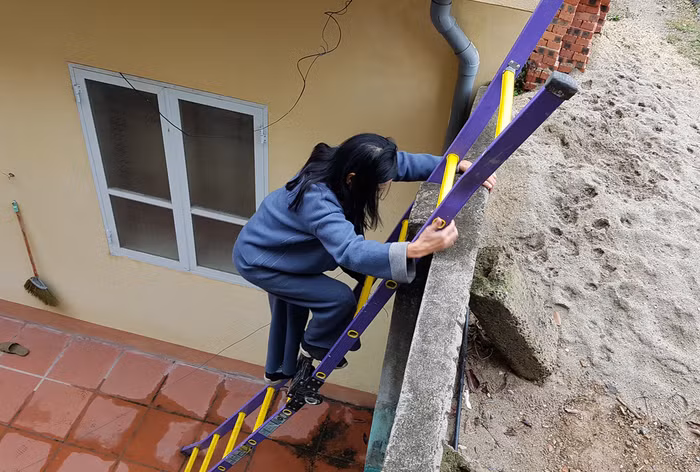 Hơn nửa tháng qua, cô giáo Quyến phải trèo thang để ra ngoài (Ảnh: Lã Tiến)