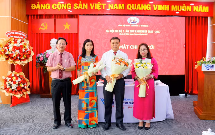 Bí thư Đảng ủy Tăng Hữu Thủy tặng hoa chúc mừng Chi ủy Chi bộ 2 nhiệm kỳ 2025-2027. Ảnh: Trung tâm Quản lý Ký túc xá, Đại học Quốc gia Thành phố Hồ Chí Minh.