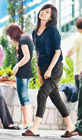 Cao Viên Viên đi vào khách sạn trong bộ dạng kéo quần cho khỏi nóng.