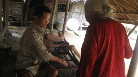 Ông Kính luôn phải giữ chặt tay đứa con khờ dại mỗi khi nó lên cơn. Ông Kính luôn phải giữ chặt tay đứa con khờ dại mỗi khi nó lên cơn.