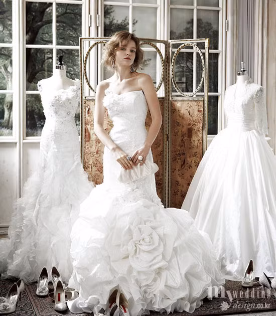 Kiêu sa, lộng lẫy với váy cưới "Nàng tiên cá". Phần chân váy tết hoa nơ bồng tuyệt đẹp, tuy nhiên sẽ hơi vướng víu khi bước đi trên giày cao gót. (Ảnh: Design) Xem thêm: Váy cưới xinh cho cô dâu hiện đại / Bí quyết chăm sóc da mềm, mịn.