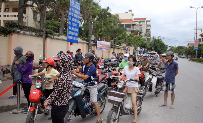 Phụ huynh chờ đón con em ra về sau môn thị Toán tại trường Trung học phổ thông Hồng Bàng.