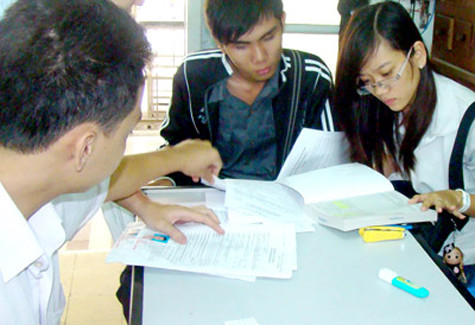 Thí sinh tìm hiểu thông tin về học phí, lệ phí để làm hồ sơ đăng ký dự thi. Ảnh: T. MINH