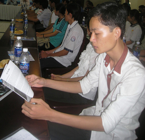 Võ Văn Thới tranh thủ đọc Cẩm nang “Tiếp sức mùa thi” trước khi được đưa về nhà trọ miễn phí.