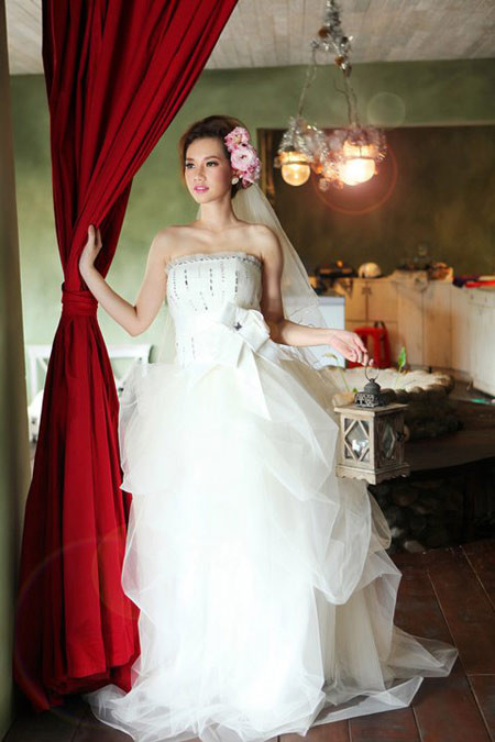 Đây là chiếc váy cưới rất tuyệt, khiến người mặc như nàng công chúa sống trong lâu đài cổ tích. Phần áo ôm quây lấy bờ vai thon, phần váy không quá bồng, nhưng được xếp tầng vô cùng điệu đà, tạo nên sự sang trọng, đài các.