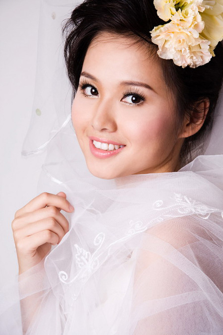 Các đường nét trên khuôn mặt thanh tú, hài hòa đến lạ. Có lẽ vì thế, chuyên gia trang điểm đã lựa kiểu tóc bới cao thanh lịch, style make up nhẹ nhàng, tinh tế dành cho hot girl xinh đẹp này. Cô dâu Tâm Tít thật long lanh với khăn voan trắng.