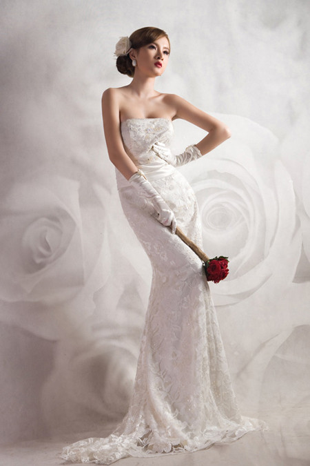 Tóc vấn lệch, cài hoa nơ sang trọng, váy thiết kế theo phom nang tiên cá. Đây thực sự là gợi ý thú vị dành cho các bạn gái có vóc dáng mảnh mai, bờ vai thon nuột nà.