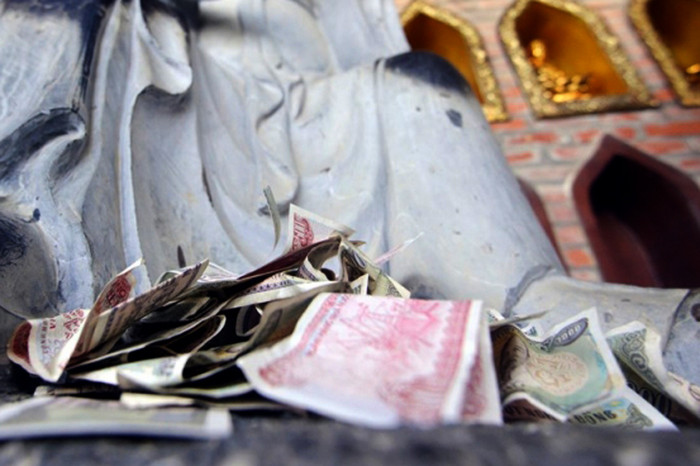 Rải tiền lẻ đầy chân tượng tại chùa. Ảnh: A.T. Rải tiền lẻ đầy chân tượng tại chùa. Ảnh: A.T.