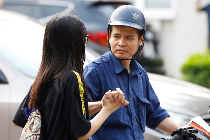 Cái nắm tay rất chắc của bố chúc con gái thi tốt. Ảnh: Tùng Dương.