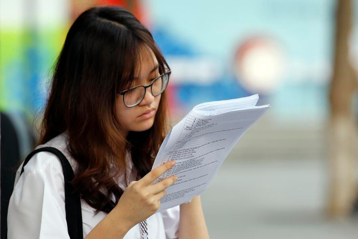 Thí sinh này quên Căn cước công dân nên phải đợi và tranh thủ ôn bài trong khi mẹ quay về nhà lấy Căn cước.Ảnh: Tùng Dương.