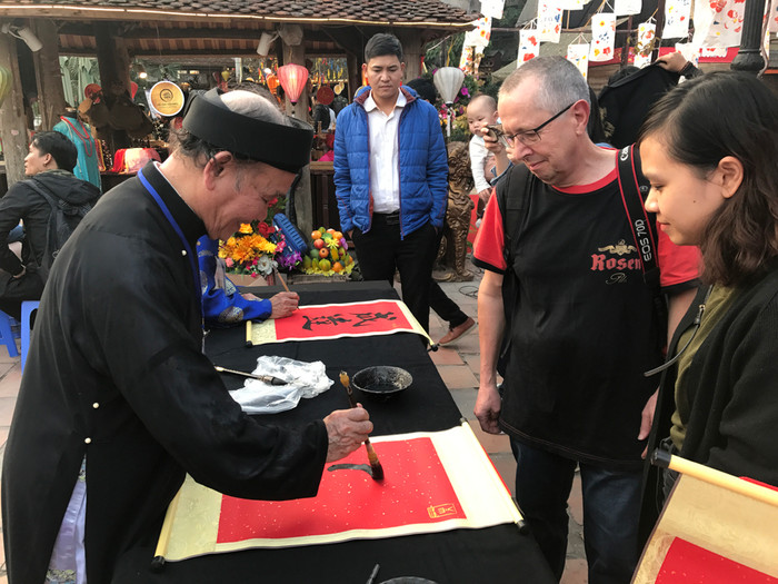 Rất nhiều du khách nước ngoài cũng đến xin chữ. Ảnh: Tùng Dương.