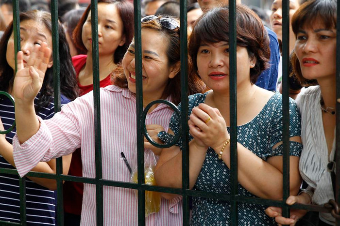 Có bà mẹ trên tay đã cầm sẵn túi nước mía vì lo con trai khát nước. Ảnh: Tùng Dương.