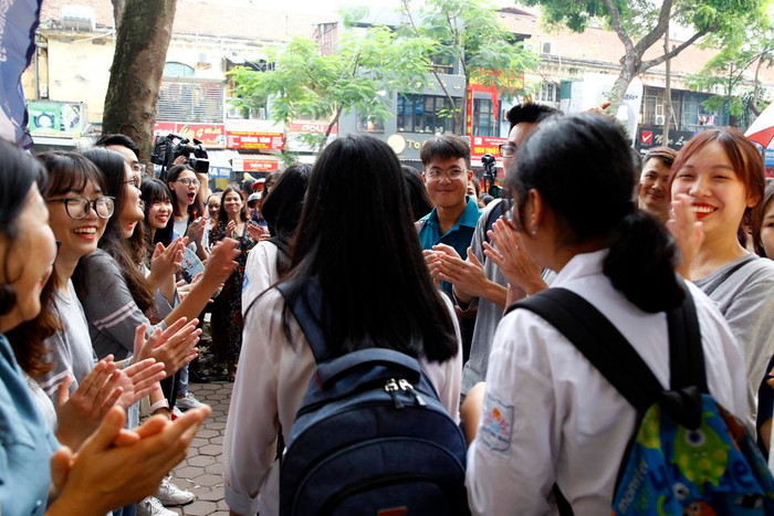 Các bạn học sinh khóa trước của Trường Trung học phổ thông Việt Đức đứng thành 2 hàng bên ngoài cổng cùng vỗ tay chào mừng các thí sinh hoàn thành môn thi. Ảnh: Tùng Dương.