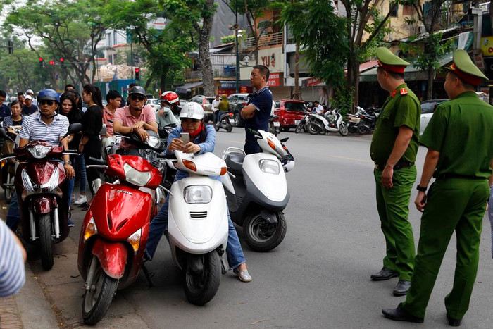 Ngoài cổng Trường Trung học phổ thông Việt Đức phụ huynh đứng chờ ngay dưới lòng đường gây cản trở giao thông. Ảnh: Tùng Dương.
