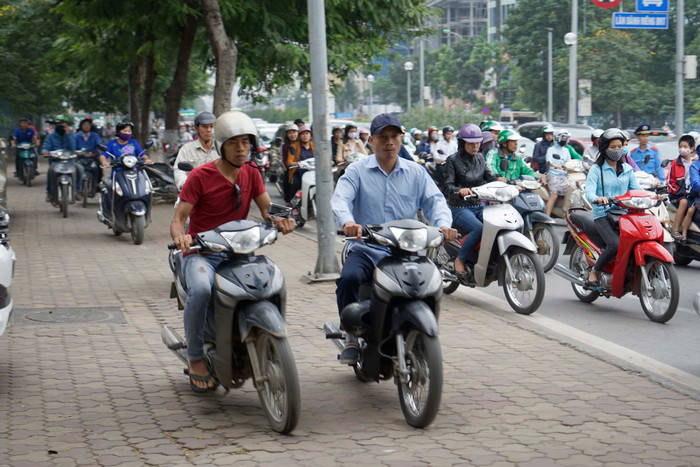 Xe máy đi tràn lên vỉa hè phố Lê Văn Lương ảnh hưởng đến người đi bộ. Ảnh: Tùng Dương. Xe máy đi tràn lên vỉa hè phố Lê Văn Lương ảnh hưởng đến người đi bộ. Ảnh: Tùng Dương.